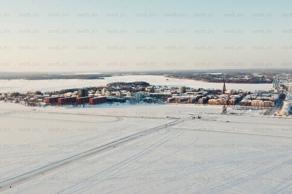 Aerial view of Luleå city center in winter snowy landscape over frozen lake and buildings