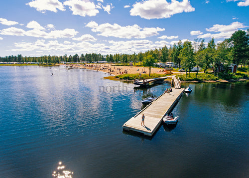 Flygfoto över en pir och strand under en ljus sommardag
