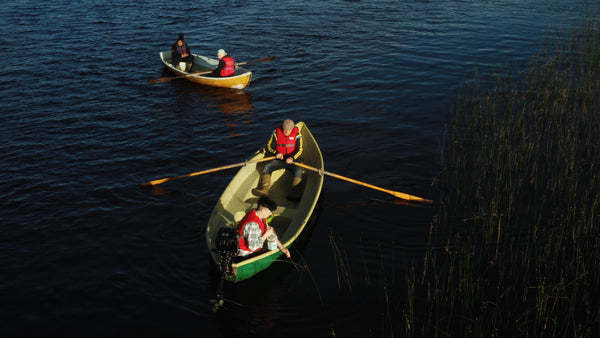 Checking crayfish traps from a boat on a calm summer day in Luleå