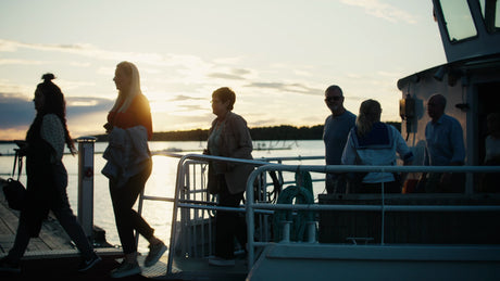 Friends and Family Disembark Boat on Pier in Luleå, Sweden at Sunset