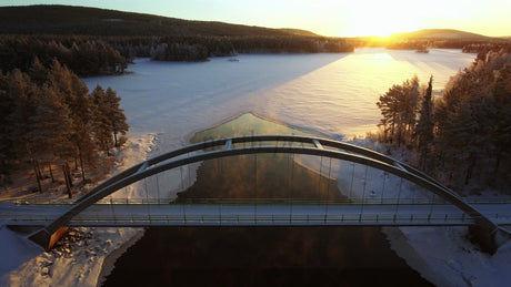 Winter Sunrise Over a Bridge in Gunnarsbyn, Sweden: An Aerial View