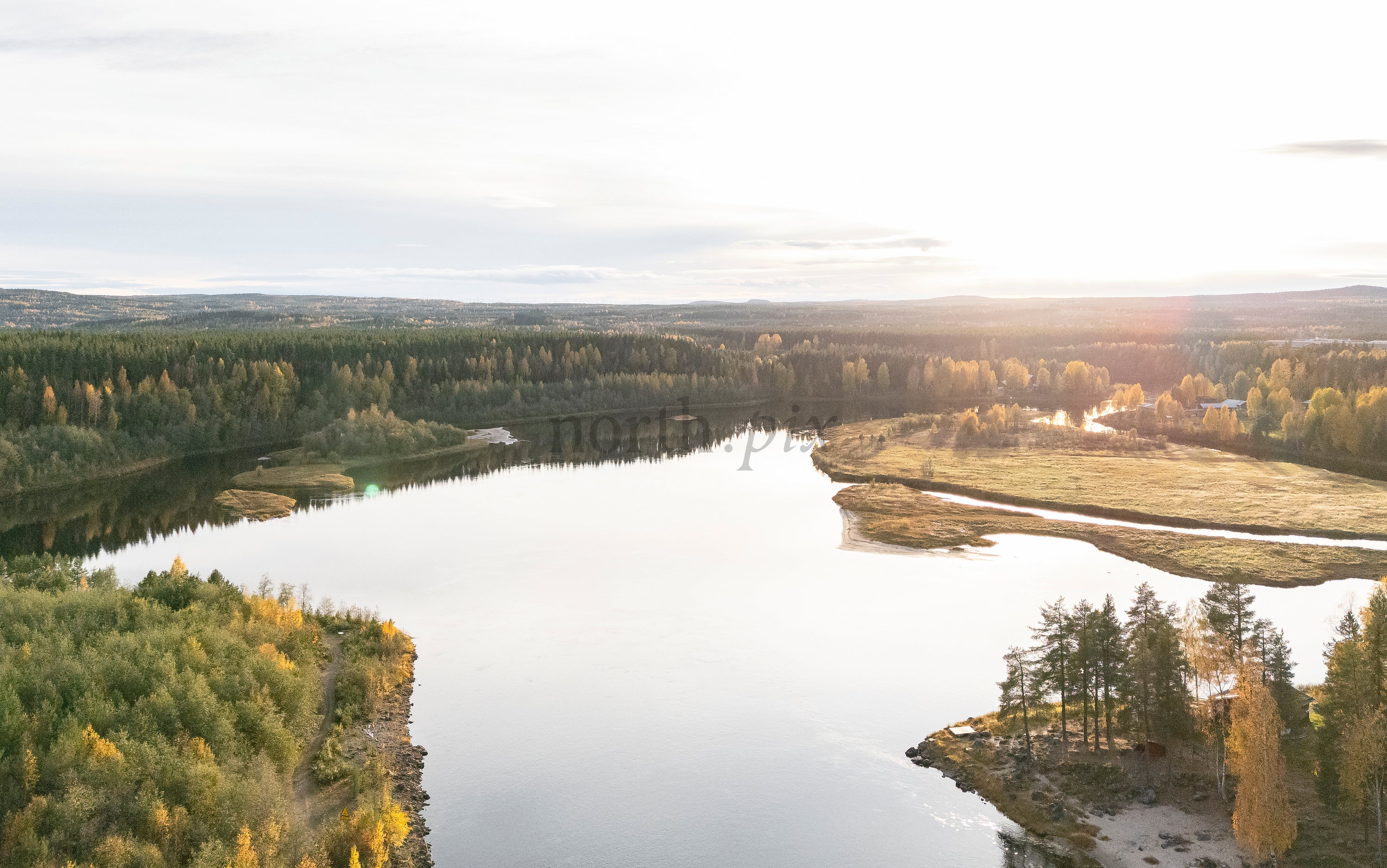 Aerial view of river bend and forest at sunset