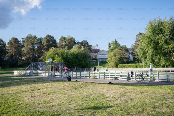 People on fenced outdoor court in summer afternoon