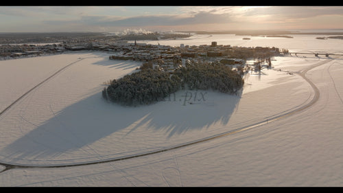Vintersolnedgång över Luleå: En fridfull drönarbild från luften över den snötäckta svenska staden