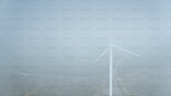 Wind turbine in foggy forest near ocean in Haraholmen