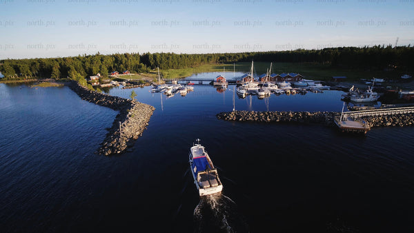 Summer day in junkön archipelago: Boat navigating Luleå̊ harbor