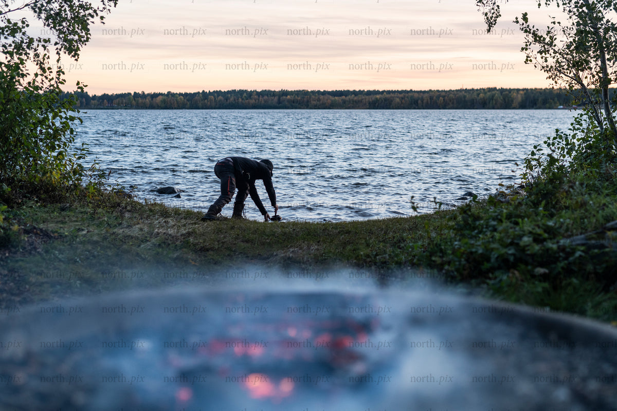 Person on lakeshore at dusk, autumn