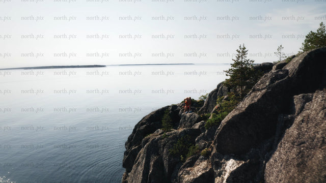 Drone view of rocky cliff and boat in Luleå archipelago, on bright summer day
