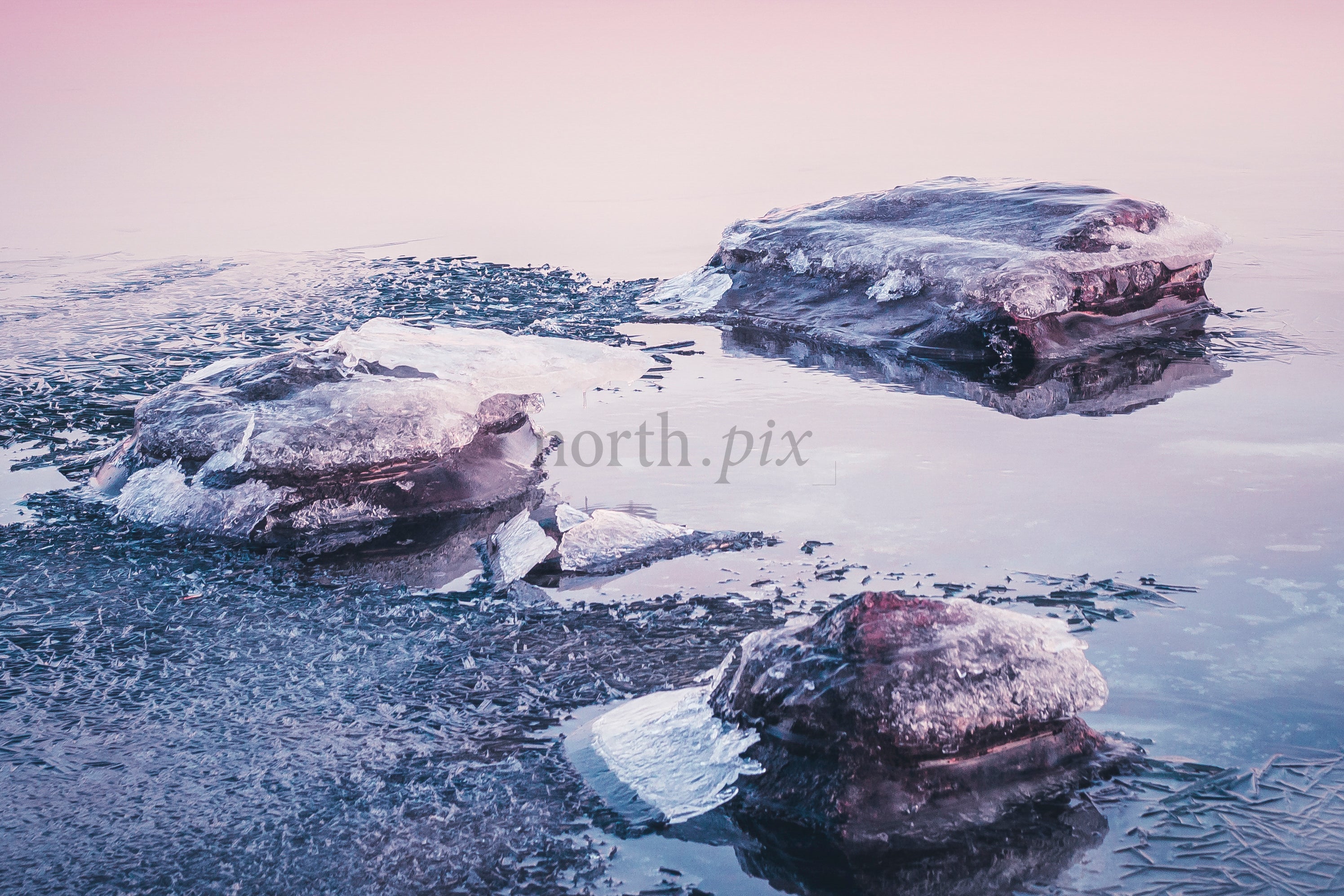 Ice formations on a partially frozen lake at sunrise