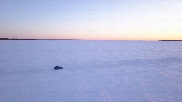 Driving on frozen ice road in lövskär archipelago at sunset