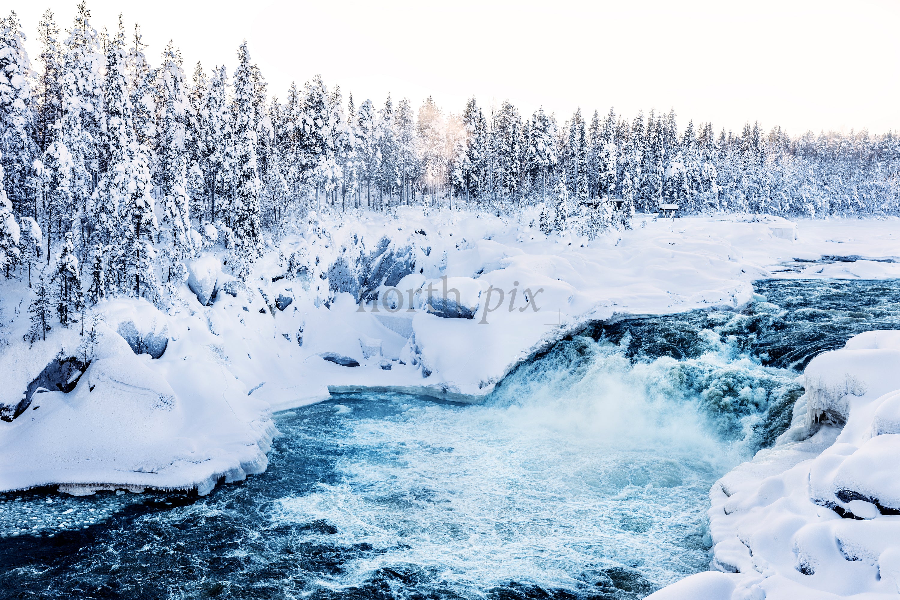 Jokkfall waterfall in snowy winter forest landscape