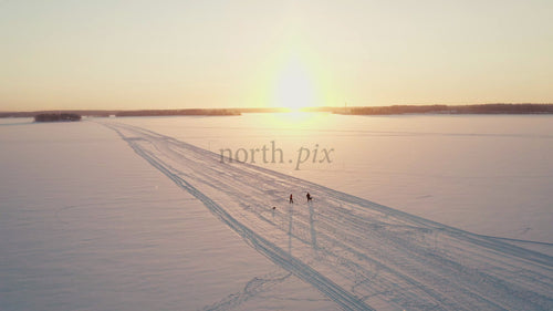 Vinterpromenad i solnedgången på en frusen sjö i Luleå, Sverige