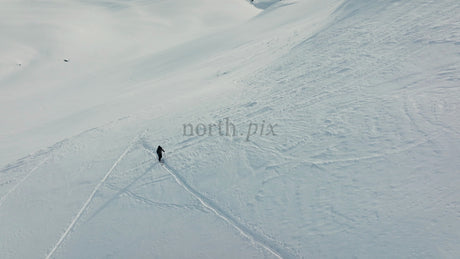 Skier Making Fresh Tracks on a Sunny Snowy Slope at Riksgränsen Ski Resort