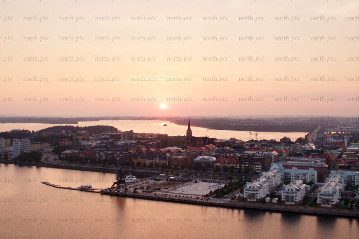 Sunset over Luleå city center by the riverfront with harbor cranes and modern housing