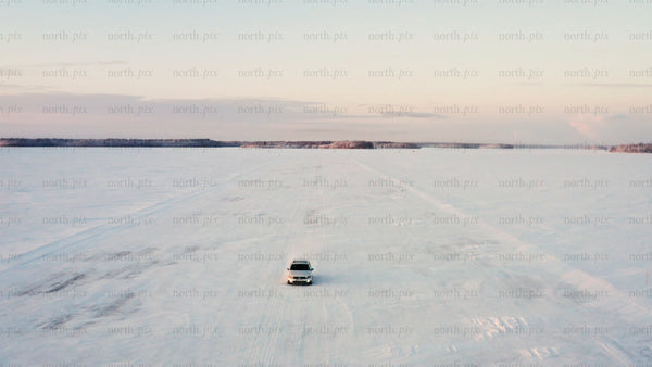 Driving on a frozen ice road in Luleå archipelago, at winter sunset