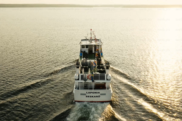Passenger ferry boat tour on calm water at sunset near Luleå city center