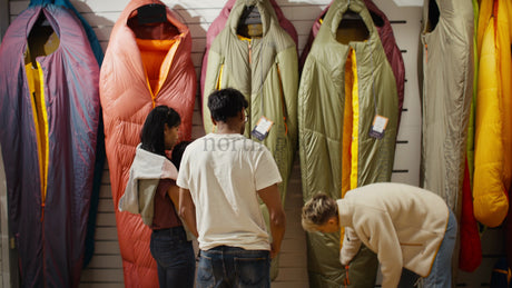 Customers Choosing Sleeping Bags in a Retail Store with Clerk Assistance