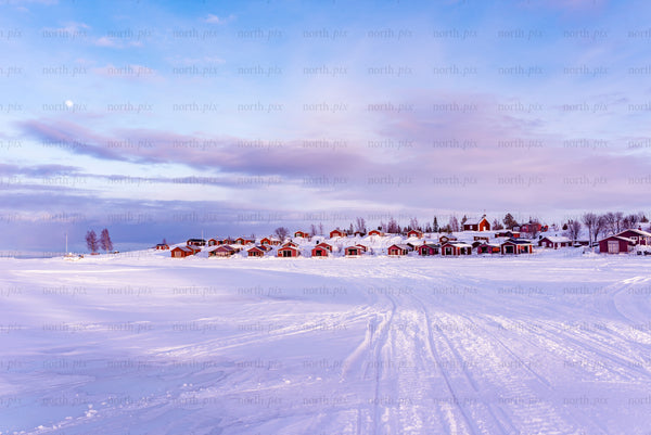 Brändöskär - snow-covered archipelago island village with red cabins at dawn
