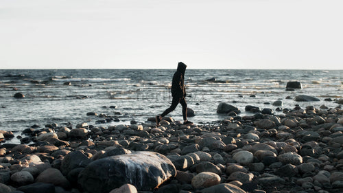 Ensam person går längs klippstranden i Luleå skärgård under sommarkvällar