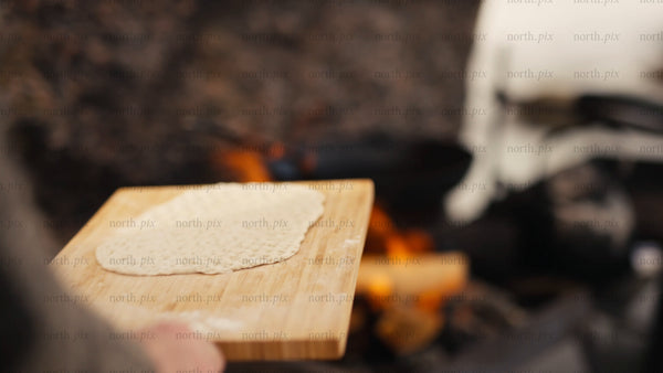 Cooking flatbread over a campfire in the Luleå archipelago, winter scene