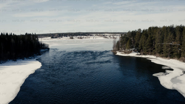 Winter drone shot of partially frozen river in Luleå