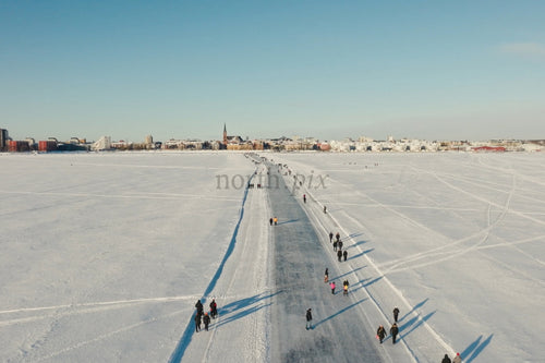 Snöiga Luleå centrum Flygfoto över frusen sjöstig och människor som går
