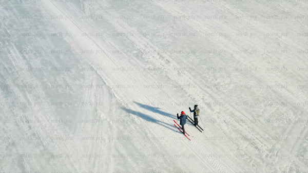 Aerial view of cross-country skiers on frozen lake in Luleå, winter day