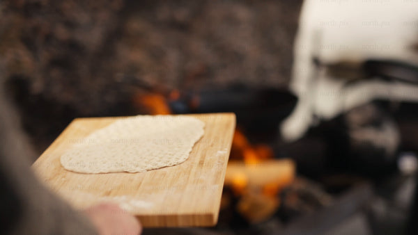 Cooking flatbread over a campfire in the Luleå archipelago, winter scene
