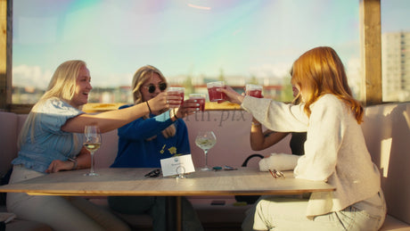 Friends Enjoying Drinks at a Rooftop Bar in Luleå, Sweden, During a Summer Evening