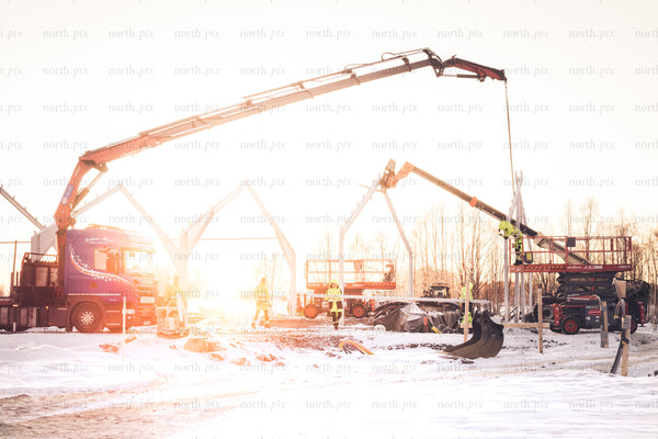 Construction site with cranes at sunrise, winter