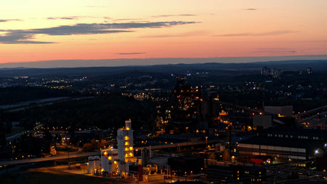 Lulea, Sweden at Dusk: Aerial View of Cityscape, Industrial Buildings, and Sunset Sky