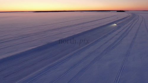 Bilkörning på isväg vid solnedgången i Luleå skärgård, Sverige