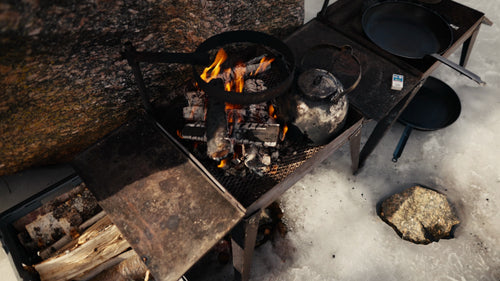 Vintermatlagning vid lägereld med marshmallows i Luleå skärgård, Sverige