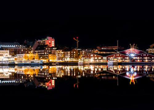 Norrbottensteatern vid vattnet med upplysta byggnader och reflektioner