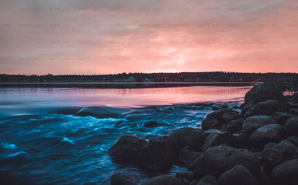 Rocky river rapids with pink sunset sky
