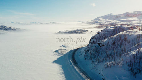 Flygfoto över snöig väg i Riksgränsenbergen med drönare