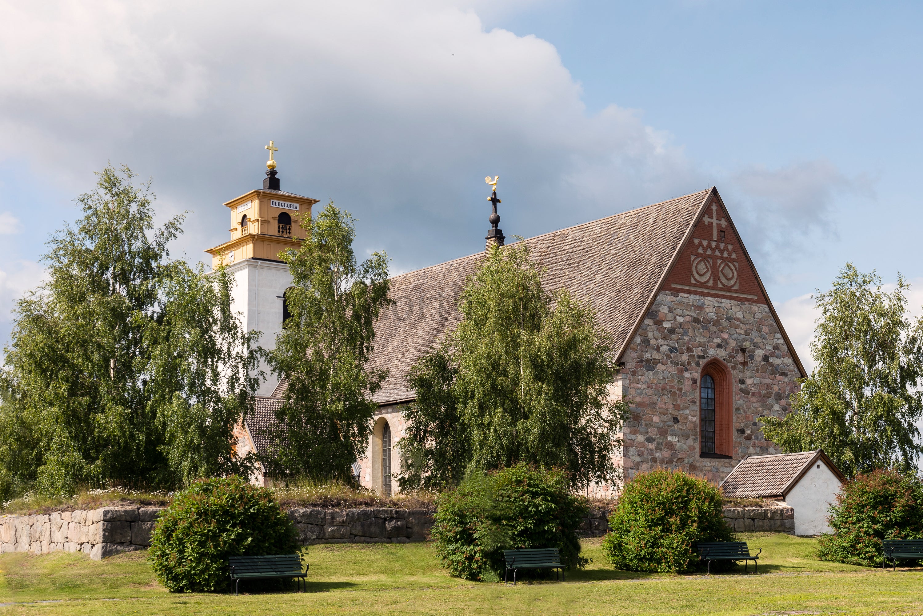 Stone church with bell tower and birch trees