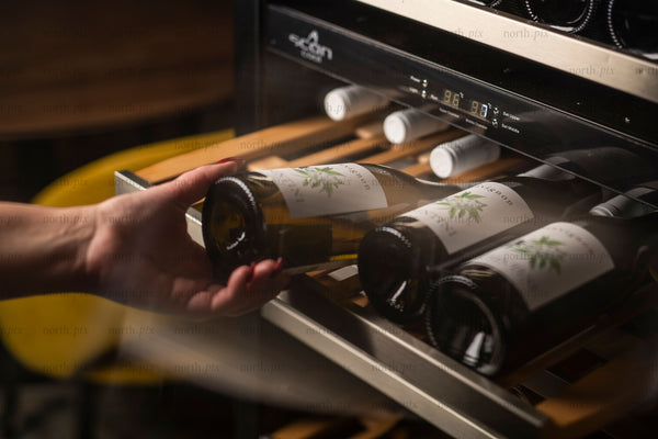 Hand removing wine bottle from wine cooler drawer