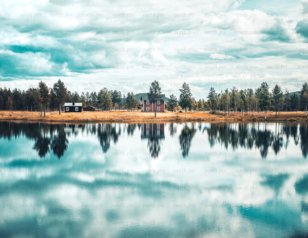 House and cabins by a lake with mirrored reflection