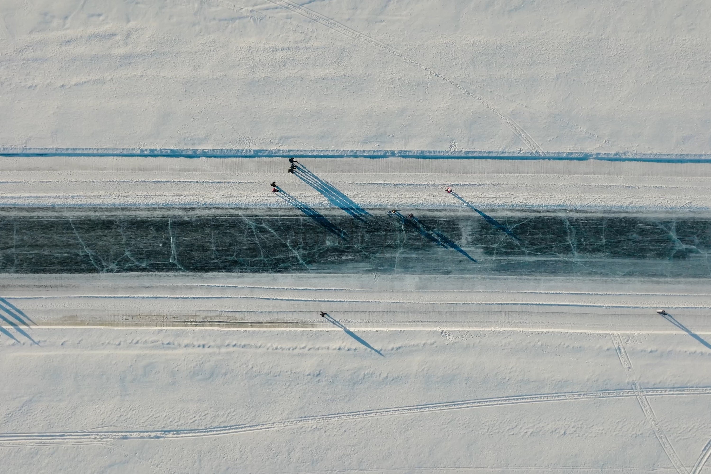 Aerial View Of Snowy Canal In Luleå City Center With Skaters And Long Shadows