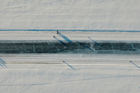 Aerial View Of Snowy Canal In Luleå City Center With Skaters And Long Shadows