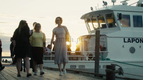 People Disembarking Boat at Sunset in Lulea, Sweden