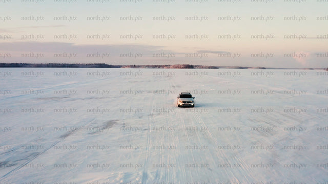 Driving on frozen ice road in Luleå archipelago at sunset