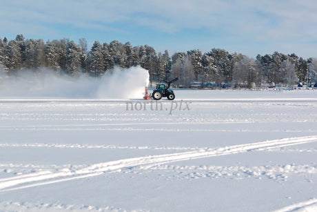 Winter Snow Field With Tractor Clearing Snow On Frozen Lake Near Luleå City Center