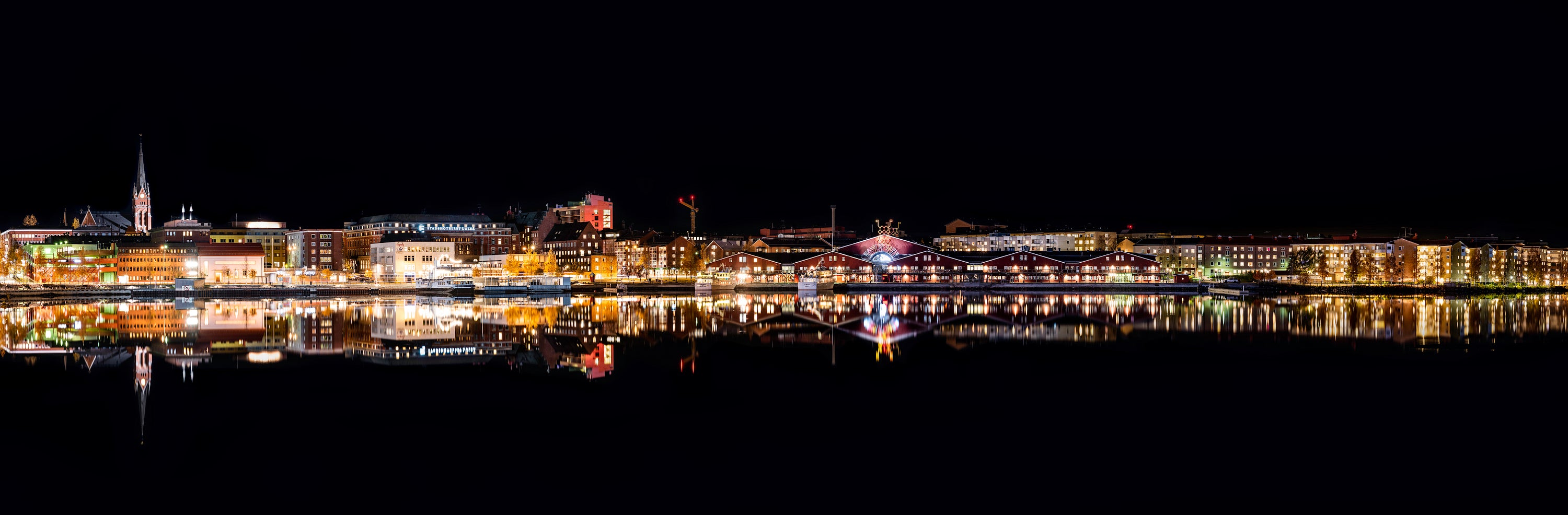 Night panorama of harbor waterfront with reflections