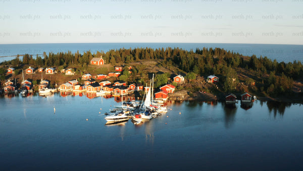 Summer sunset over brando archipelago: Red cabins and boats in the Swedish sea