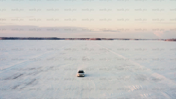 Driving on a frozen ice road in Luleå archipelago, at winter sunset