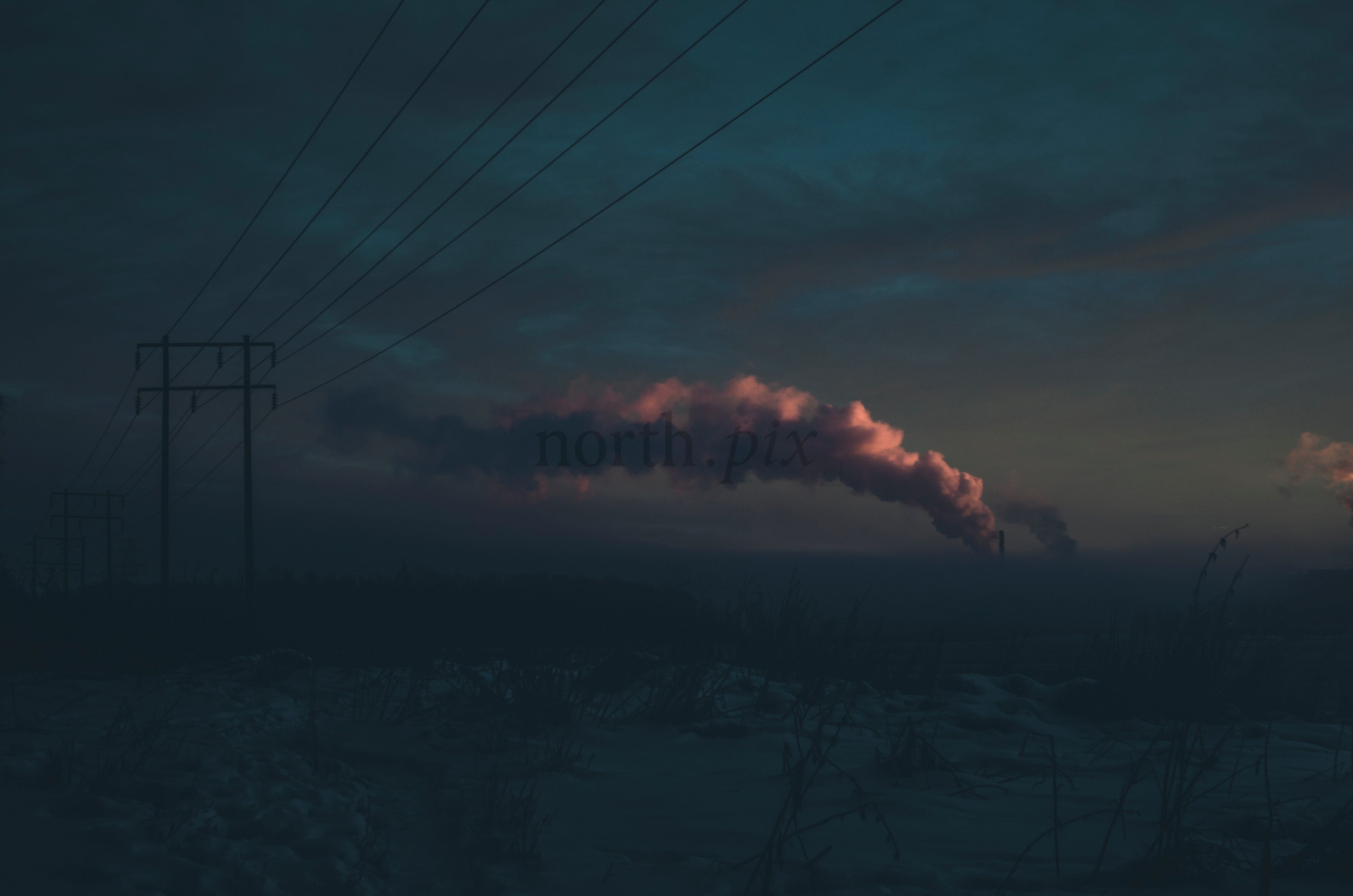 Power lines and factory smoke at dusk in winter