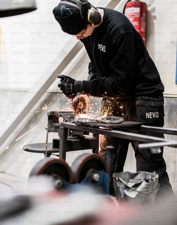 Worker using angle grinder in industrial workshop