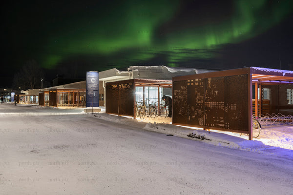 Bike shelter and bicycles under northern lights at night